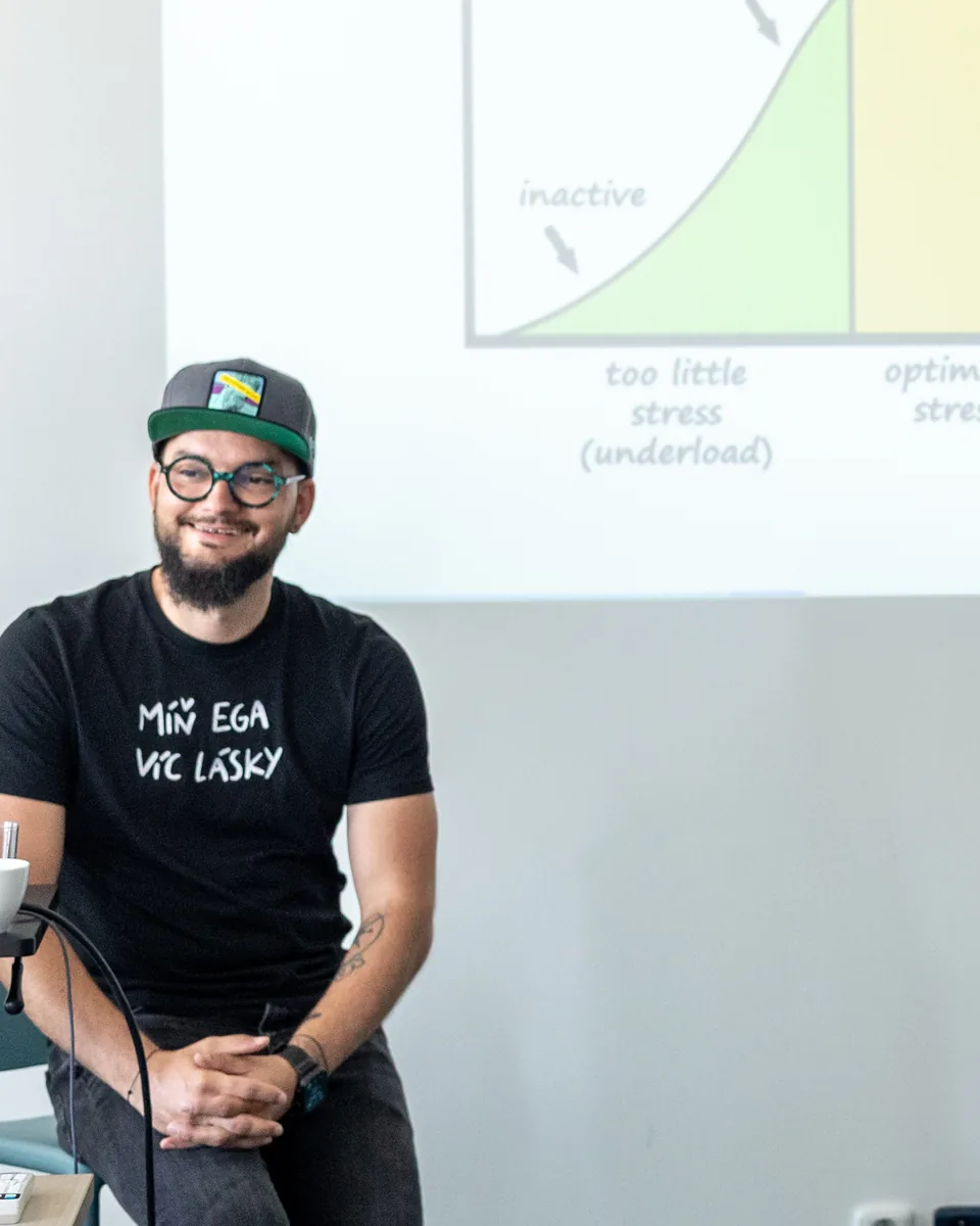 Adrian Raven před křivkou stresu na workshopu o prevenci vyhoření.